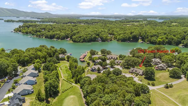 an aerial view of a house with swimming pool and a chairs
