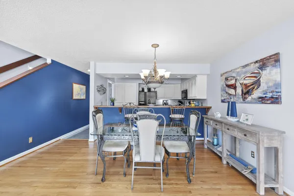 a view of a dining room with furniture a chandelier and wooden floor