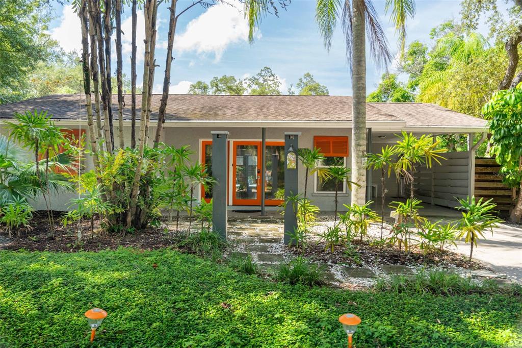 680 41st Street Sarasota, FL 34234 - Photo 1 of 42 a view of a garden with plants and a bench