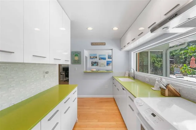 a bathroom with a tub a sink and a large window