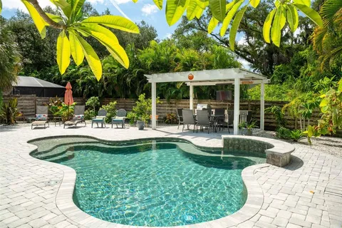 a view of a house with swimming pool and sitting area
