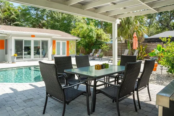a view of house with backyard outdoor seating and hardwood floor