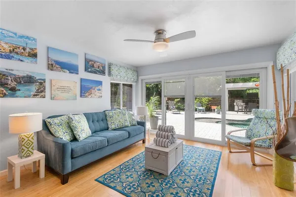 a living room with furniture flat screen tv and a large window