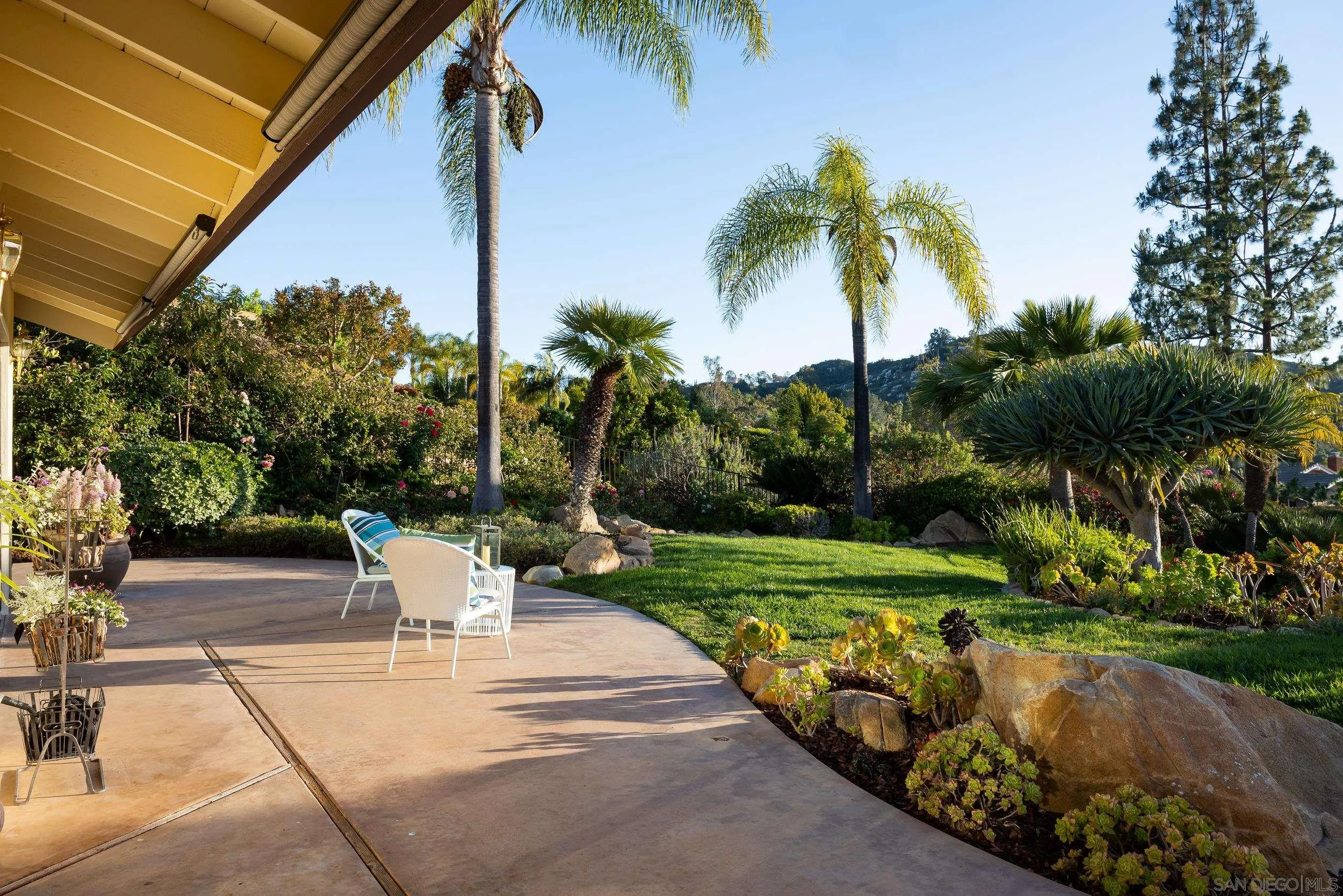 15951 Lime Grove Road Poway, CA 92064 - Photo 34 of 52 a view of a patio with a table and chairs under palm trees