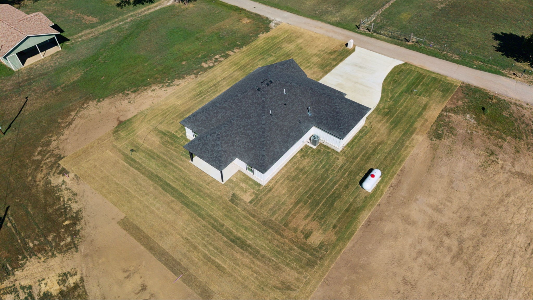 25036 South 4205 Road Inola, OK 74036 - Photo 28 of 30 Newly constructed residence featuring a dark shingled roof, light-colored exterior siding, and a concrete driveway