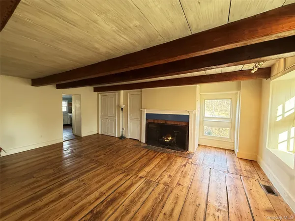 a view of empty room with wooden floor and fireplace