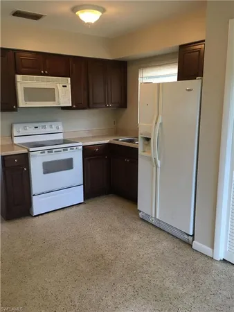 a kitchen with stainless steel appliances granite countertop a refrigerator stove and sink
