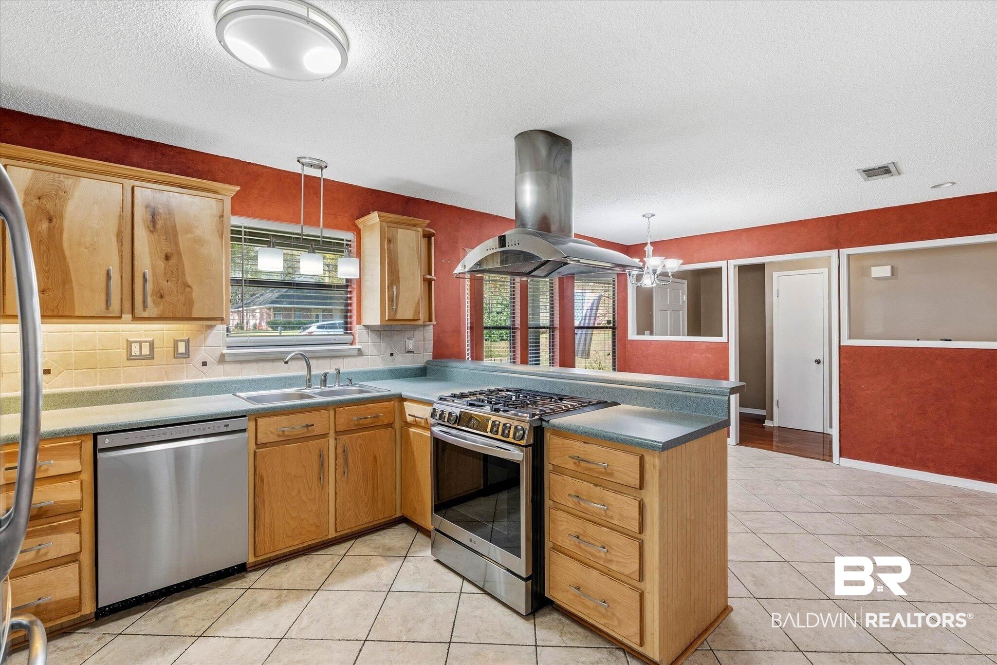8030 Country Drive Mobile, AL 36619 - Photo 8 of 22 Kitchen featuring stainless steel appliances, island exhaust hood, hanging light fixtures, a peninsula, and a textured ceiling