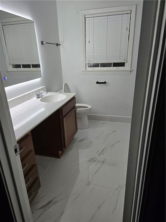 1302 Stephens Street Southwest Lilburn, GA 30047 - Photo 13 of 13 a bathroom with a sink a toilet and a mirror