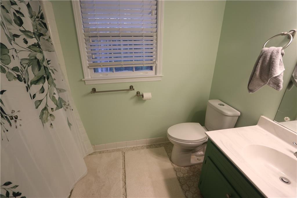 1302 Stephens Street Southwest Lilburn, GA 30047 - Photo 8 of 13 a bathroom with a sink a toilet and shower