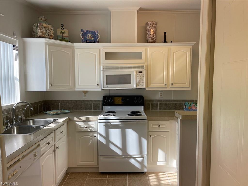 11262 Olive Circle Punta Gorda, FL 33955 - Photo 3 of 18 a kitchen with white cabinets and appliances