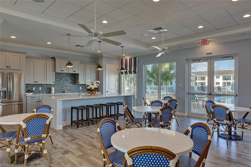 2295 Sawyers Hill Road, Unit 1007 Naples, FL 34120 - Photo 12 of 12 a view of a dining room with furniture window and wooden floor