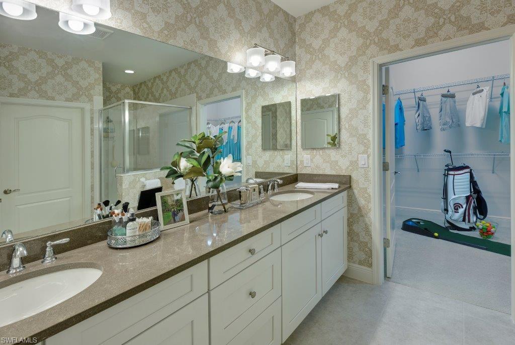 2295 Sawyers Hill Road, Unit 1007 Naples, FL 34120 - Photo 6 of 12 a bathroom with a double vanity sink and a mirror