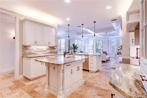 a kitchen with granite countertop a sink a stove and cabinets