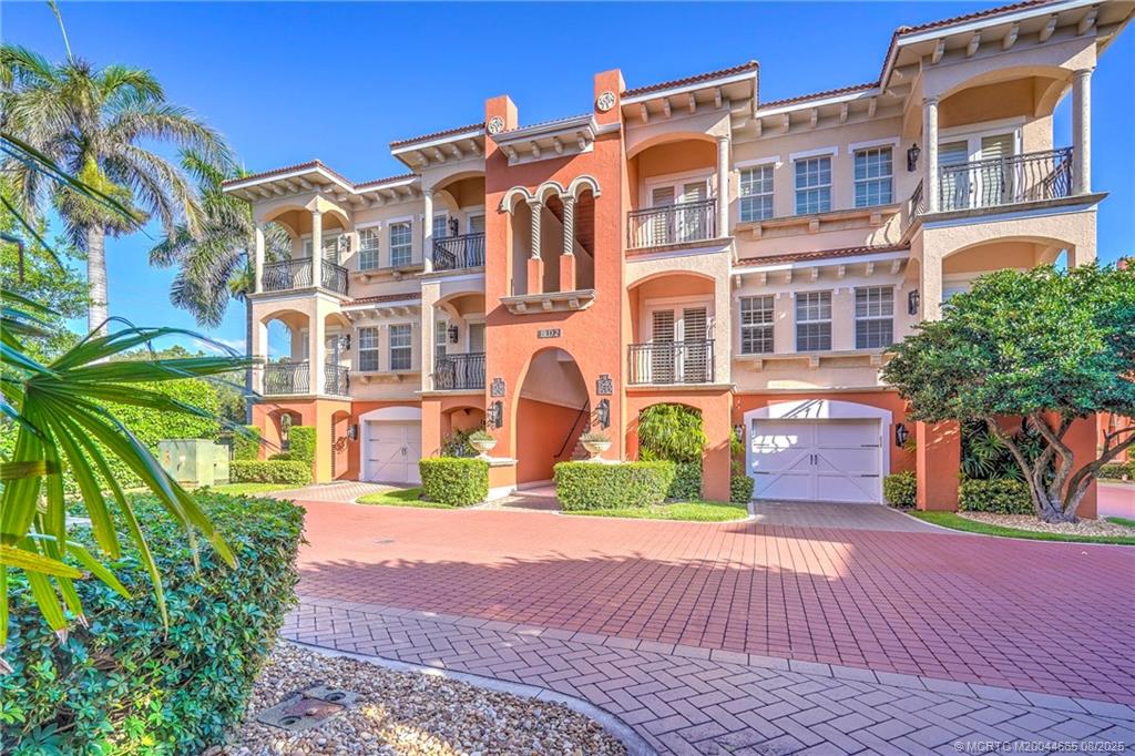 1528 Northeast Outrigger Landings Drive, Unit 208 Jensen Beach, FL 34957 - Photo 2 of 79 a front view of a residential apartment building with a yard