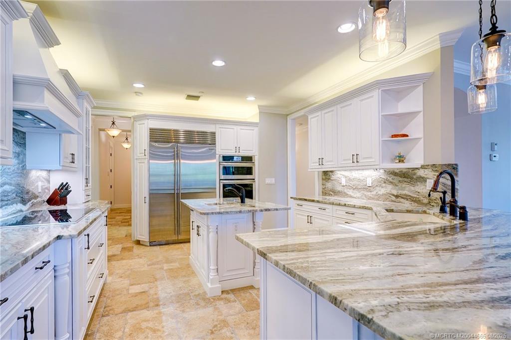 1528 Northeast Outrigger Landings Drive, Unit 208 Jensen Beach, FL 34957 - Photo 21 of 79 a kitchen with stainless steel appliances granite countertop a sink and a refrigerator