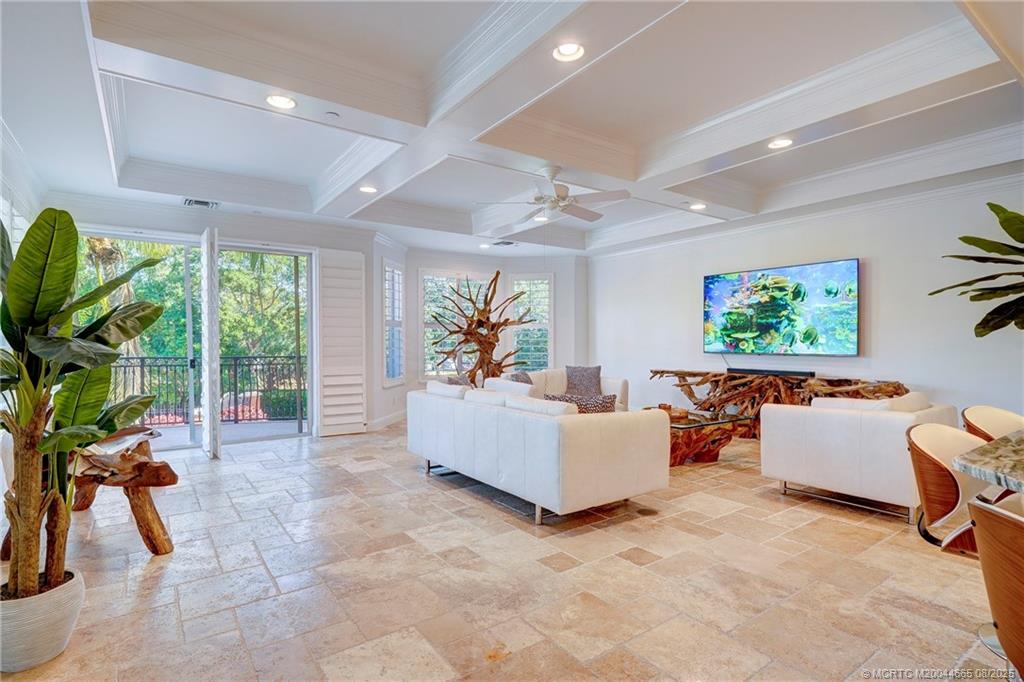 1528 Northeast Outrigger Landings Drive, Unit 208 Jensen Beach, FL 34957 - Photo 22 of 79 a living room with furniture floor to ceiling window and a flat screen tv