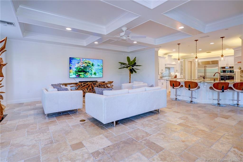 1528 Northeast Outrigger Landings Drive, Unit 208 Jensen Beach, FL 34957 - Photo 25 of 79 a living room with furniture and a flat screen tv