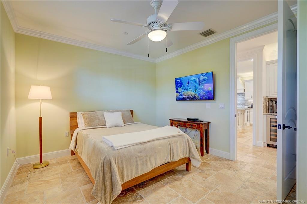 1528 Northeast Outrigger Landings Drive, Unit 208 Jensen Beach, FL 34957 - Photo 39 of 79 a bedroom with a bed and a lamp