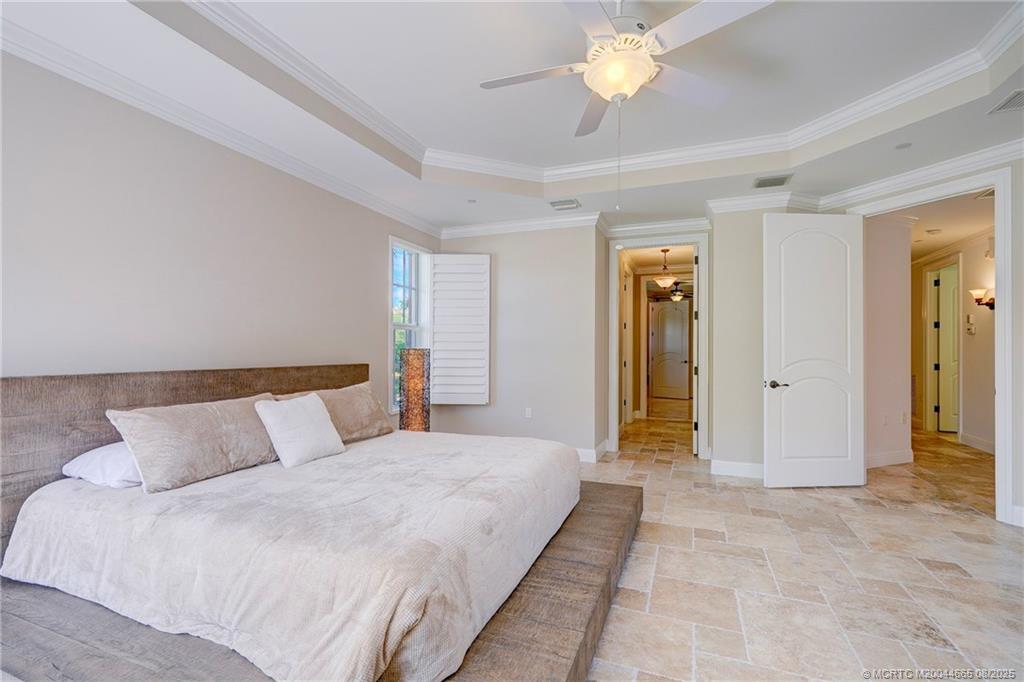 1528 Northeast Outrigger Landings Drive, Unit 208 Jensen Beach, FL 34957 - Photo 48 of 79 a bedroom with a bed and a chandelier