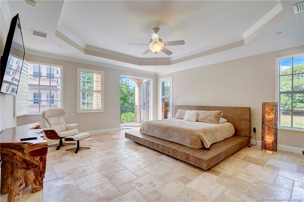 1528 Northeast Outrigger Landings Drive, Unit 208 Jensen Beach, FL 34957 - Photo 49 of 79 a spacious bedroom with a bed and large windows