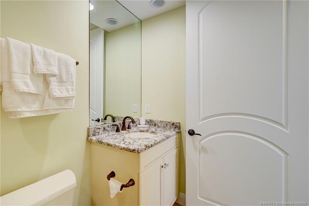 1528 Northeast Outrigger Landings Drive, Unit 208 Jensen Beach, FL 34957 - Photo 50 of 79 a bathroom with a granite countertop sink and a mirror