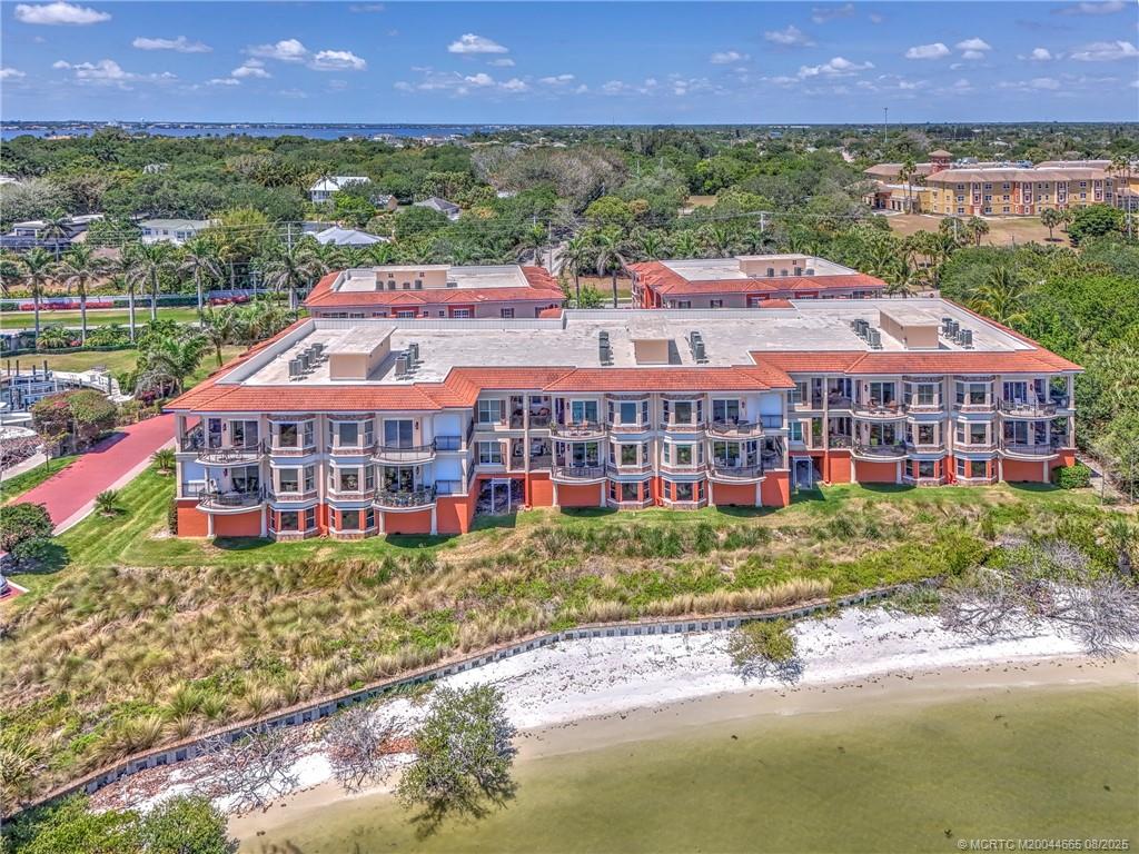 1528 Northeast Outrigger Landings Drive, Unit 208 Jensen Beach, FL 34957 - Photo 74 of 79 a view of a big room with a big yard and large trees