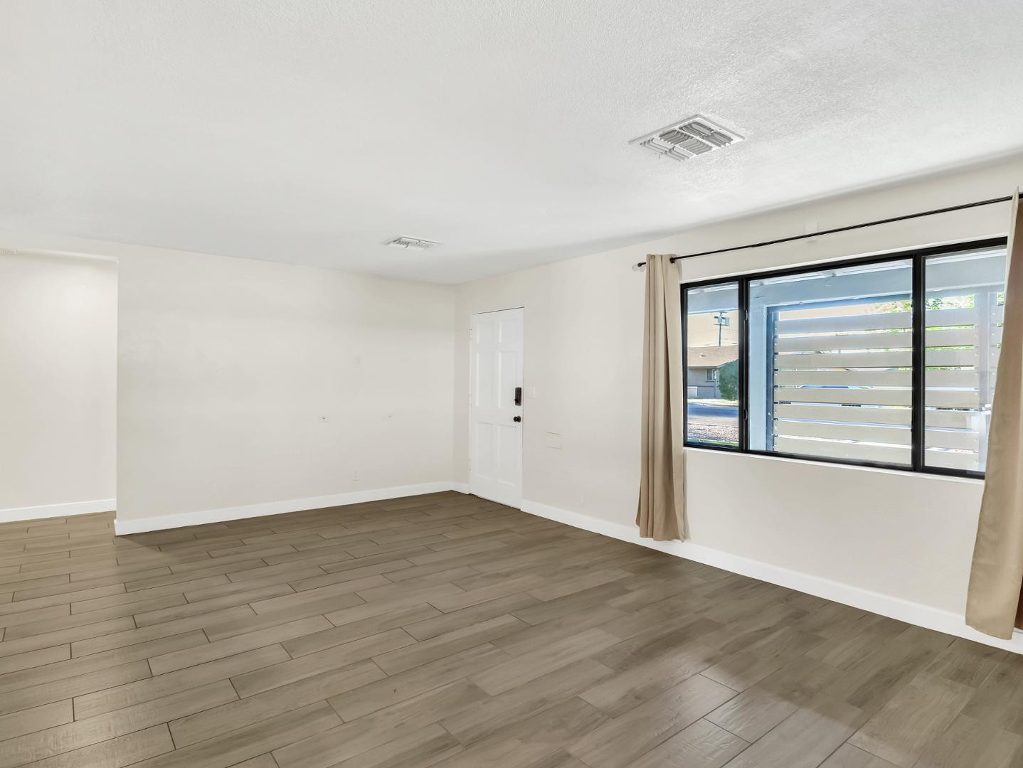 544 West 17th Place Tempe, AZ 85281 - Photo 5 of 38 a view of an empty room with wooden floor and a window