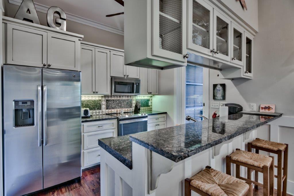 309 Defuniak Street Santa Rosa Beach, FL 32459 - Photo 16 of 53 a kitchen with stainless steel appliances granite countertop a sink refrigerator and cabinets