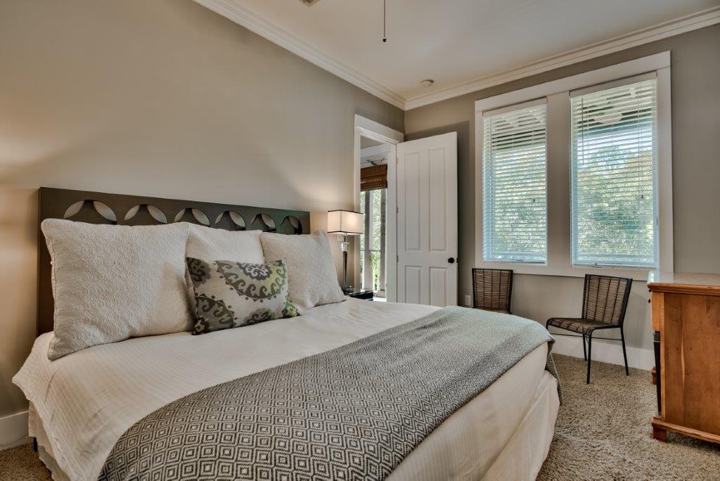 309 Defuniak Street Santa Rosa Beach, FL 32459 - Photo 24 of 53 a bedroom with a large bed and a chair next to a window