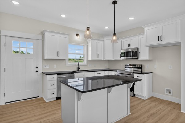 1233 Coleytown Road Lafayette, TN 37083 - Photo 11 of 39 a kitchen with stainless steel appliances granite countertop a sink a stove a refrigerator and white cabinets with wooden floor