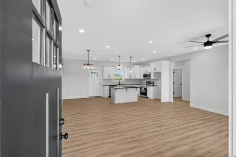 a view of kitchen with kitchen island white cabinets and wooden floor
