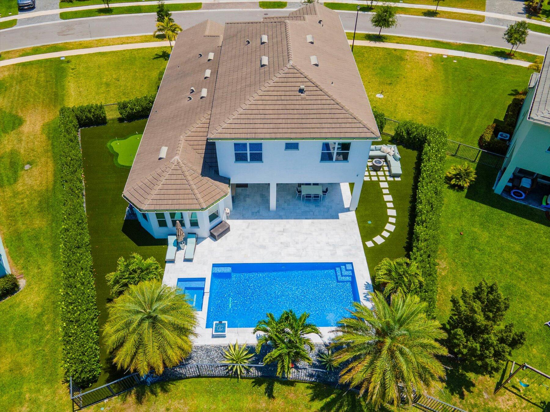 an aerial view of a house with swimming pool garden and patio