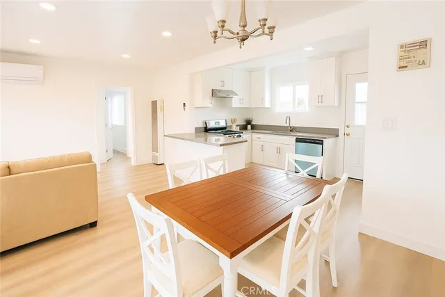 a kitchen with a table chairs refrigerator and microwave