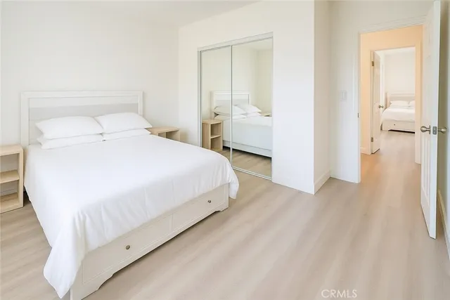 a large bedroom with a bed and wooden floor