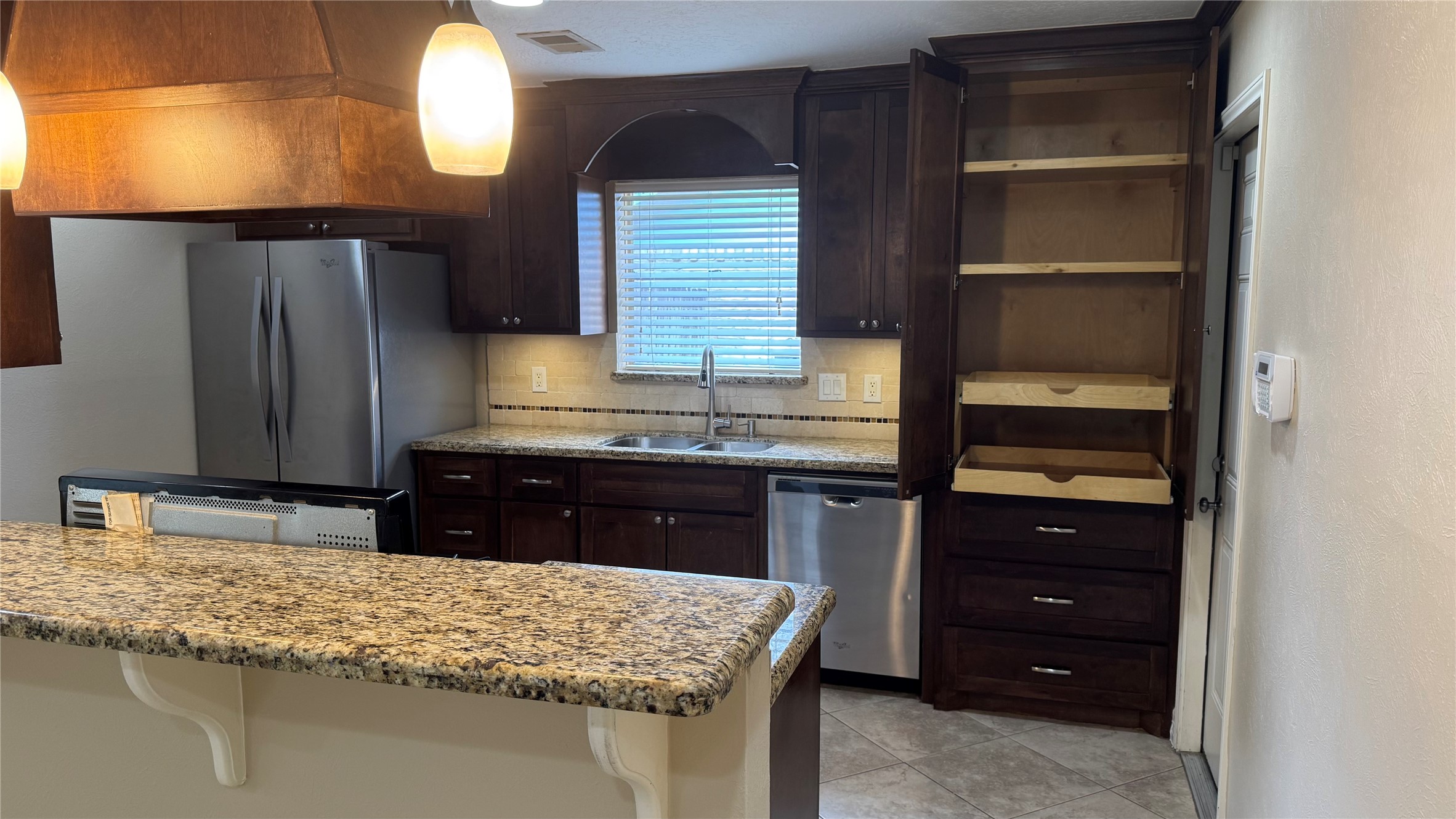 3310 Glen Spring Drive Houston, TX 77339 - Photo 9 of 18 a kitchen with kitchen island granite countertop wooden cabinets and a sink
