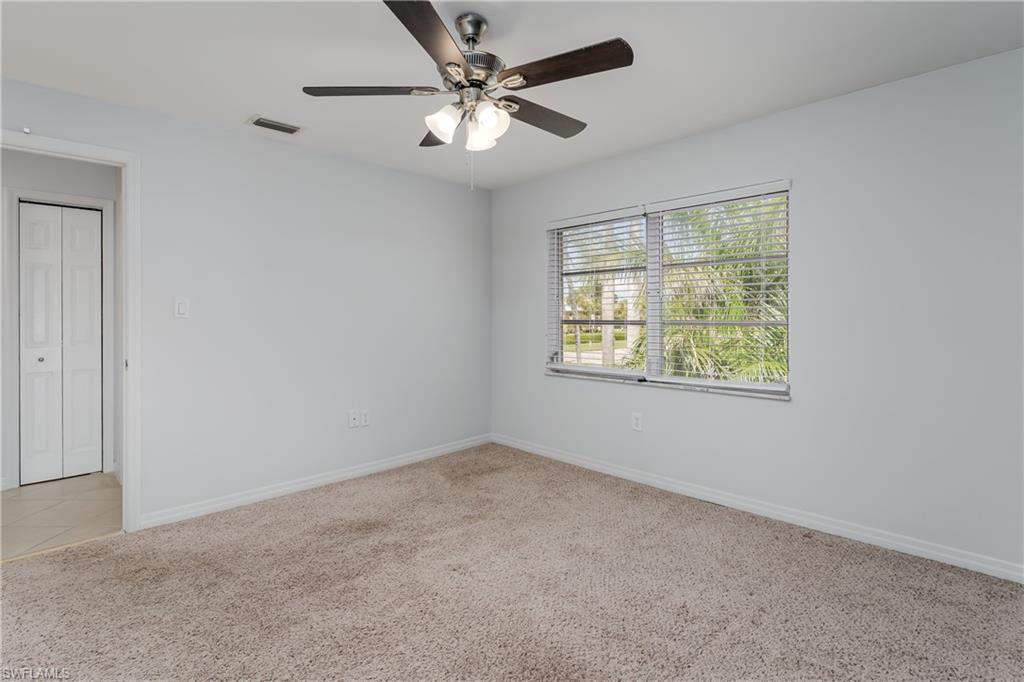 180 Cypress Way East, Unit B212 Naples, FL 34110 - Photo 18 of 40 an empty room with windows and fan
