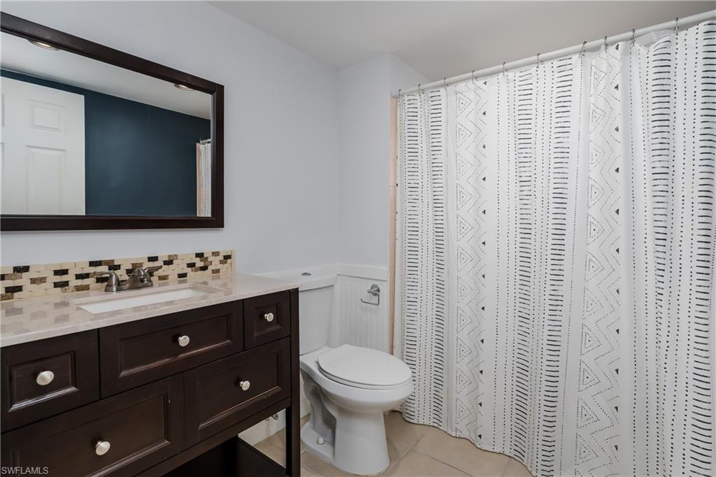 180 Cypress Way East, Unit B212 Naples, FL 34110 - Photo 20 of 40 a bathroom with a toilet sink and mirror