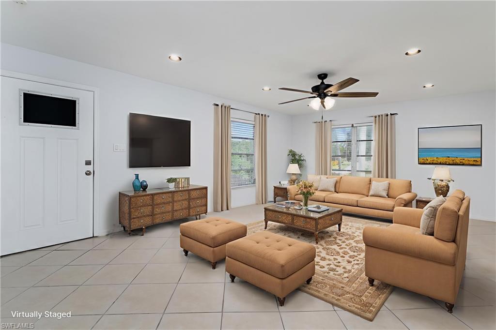 180 Cypress Way East, Unit B212 Naples, FL 34110 - Photo 2 of 40 a living room with furniture and a flat screen tv