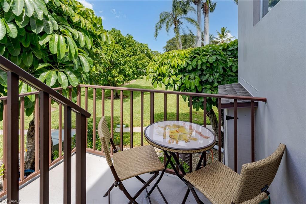 180 Cypress Way East, Unit B212 Naples, FL 34110 - Photo 27 of 40 a view of a chairs and table in patio