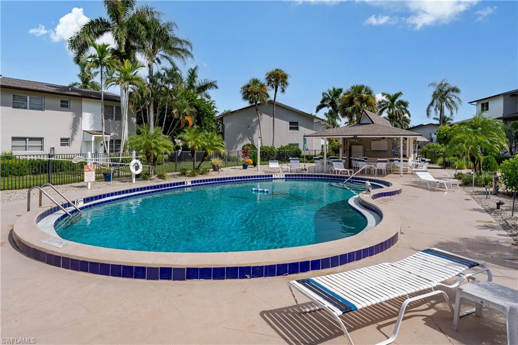 180 Cypress Way East, Unit B212 Naples, FL 34110 - Photo 29 of 40 a view of a swimming pool with a patio