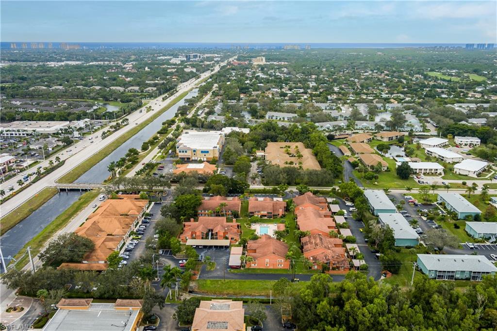 180 Cypress Way East, Unit B212 Naples, FL 34110 - Photo 34 of 40 an aerial view of residential building and lake