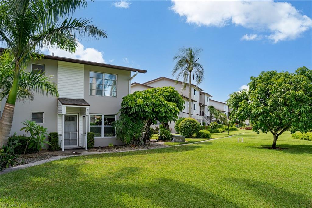 180 Cypress Way East, Unit B212 Naples, FL 34110 - Photo 40 of 40 a front view of house with yard and green space
