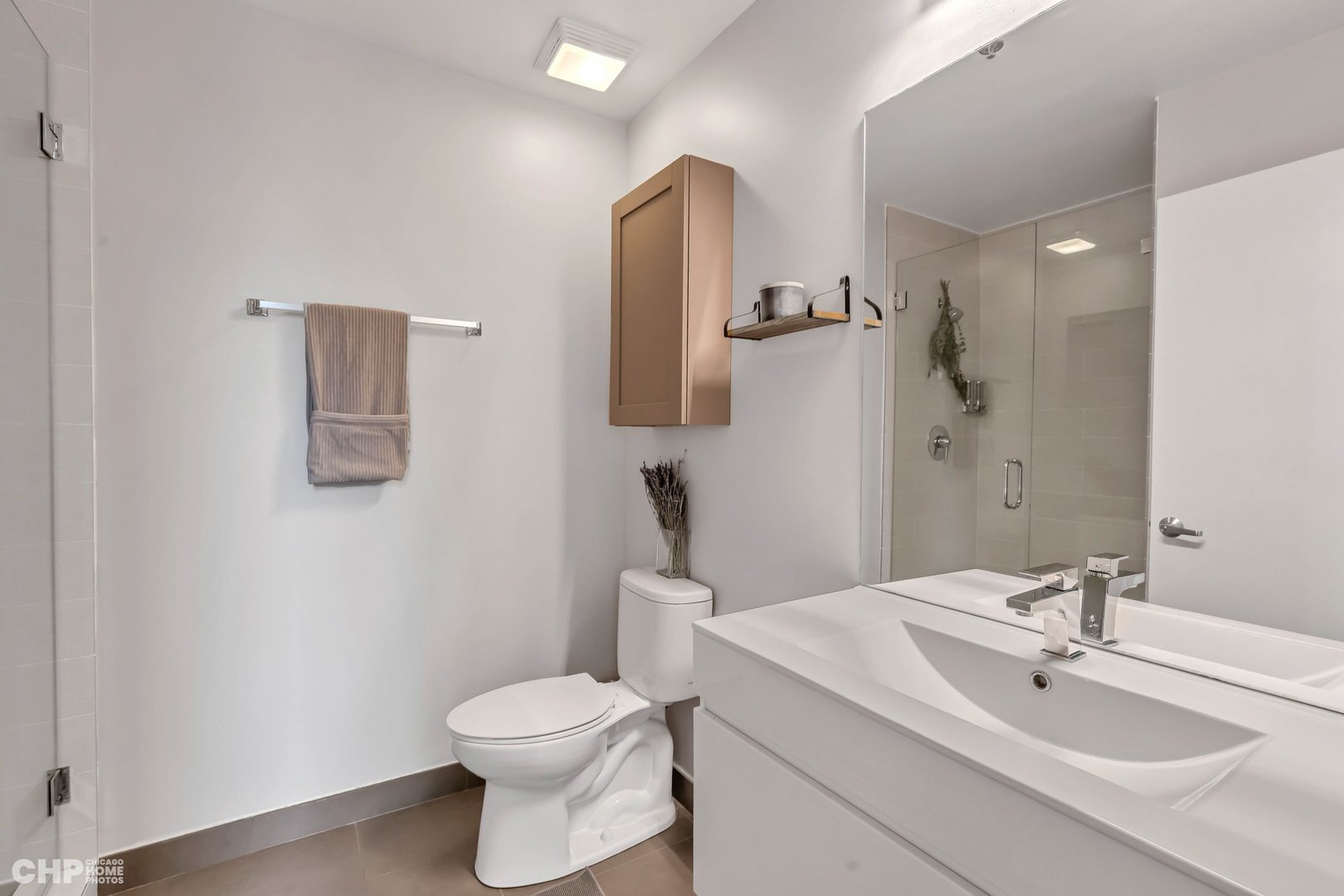 320 East 21st Street, Unit 617 Chicago, IL 60616 - Photo 15 of 23 a bathroom with a toilet sink vanity and mirror