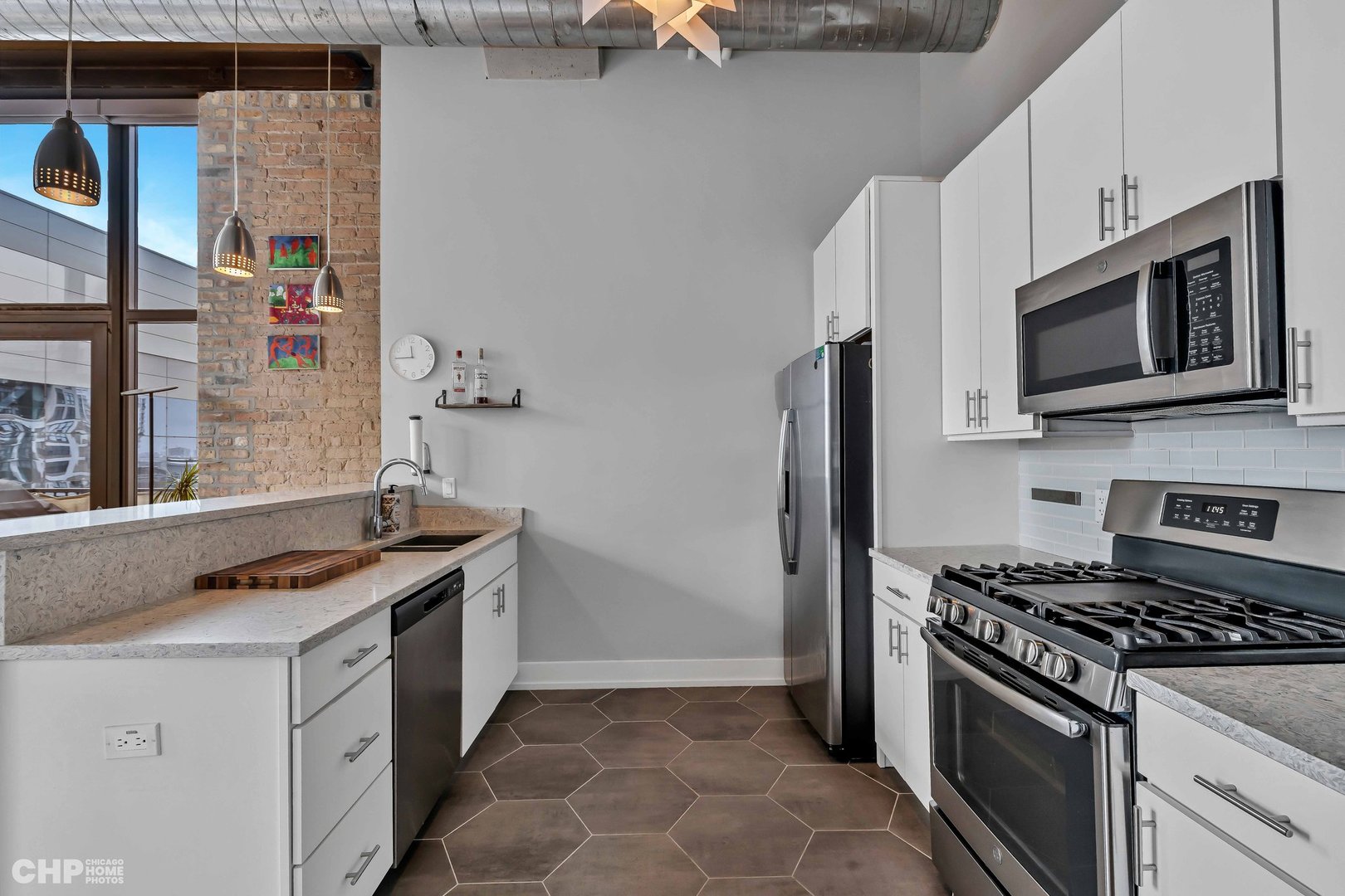 320 East 21st Street, Unit 617 Chicago, IL 60616 - Photo 5 of 23 a kitchen with stainless steel appliances granite countertop a stove and a microwave