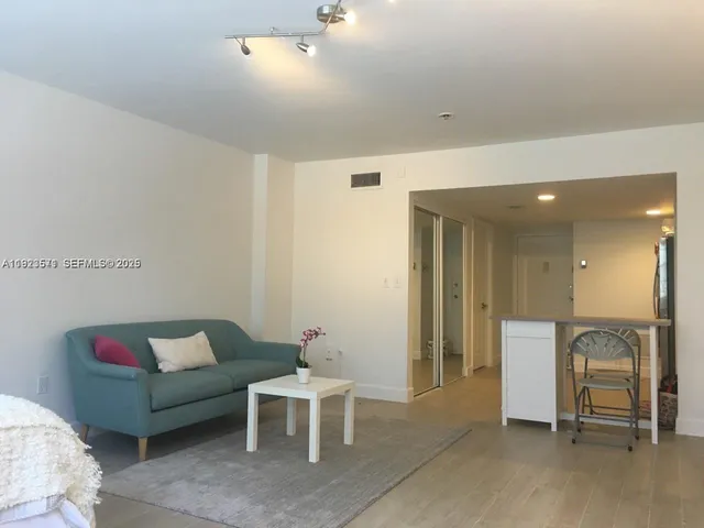a living room with furniture and a dining table with kitchen view