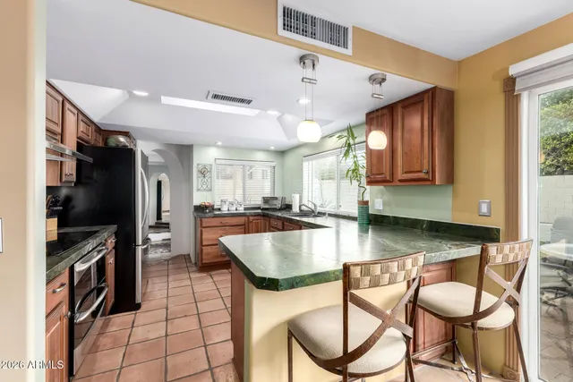 a kitchen with stainless steel appliances granite countertop a sink dishwasher stove and oven