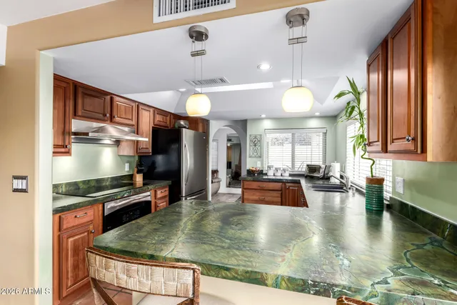 a kitchen with granite countertop a sink and wooden cabinets