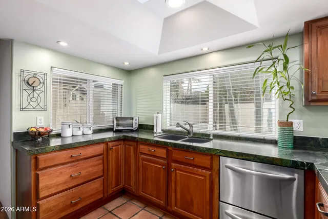 a kitchen with granite countertop stainless steel appliances and wooden cabinets