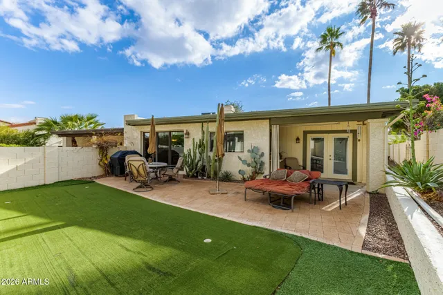 a view of a house with backyard and sitting area